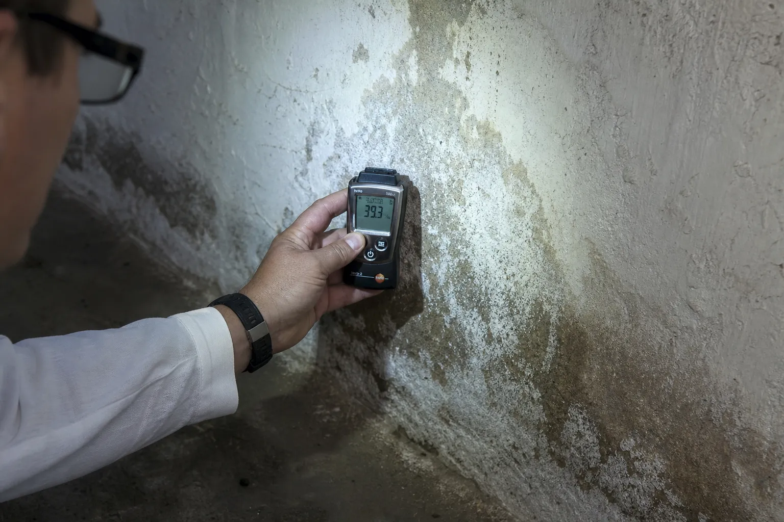 Expert contrôlant l’humidité d’un sous-sol lors d’une expertise avant achat à Juvisy-sur-Orge
